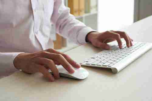 man computing on white keyboard